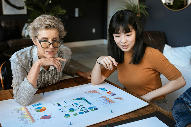 elderly woman and young woman looking at charts together