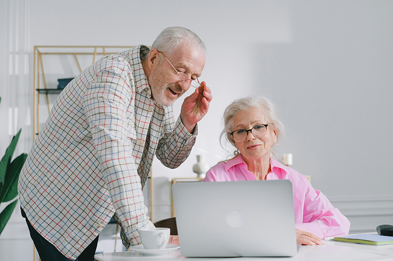 elderly couple looking at a laptop