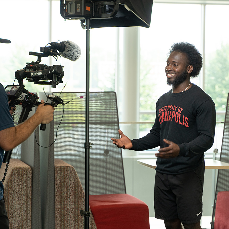 student smiling in front of a camera