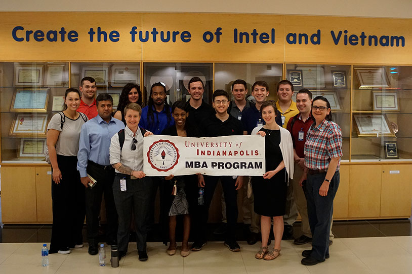 group of students in Vietnam holding a sign: University of Indianapolis MBA Program