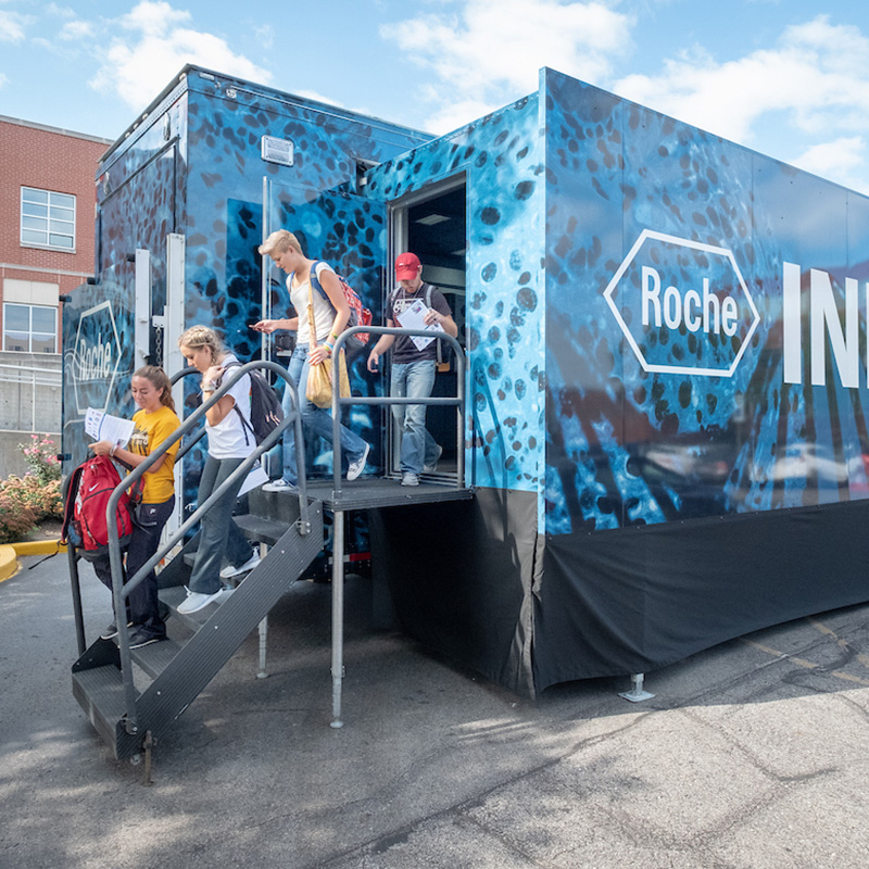 students near the Roche mobile lab