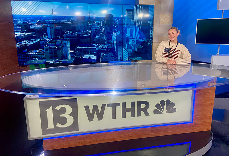 student standing at the news anchor's desk on WTHR