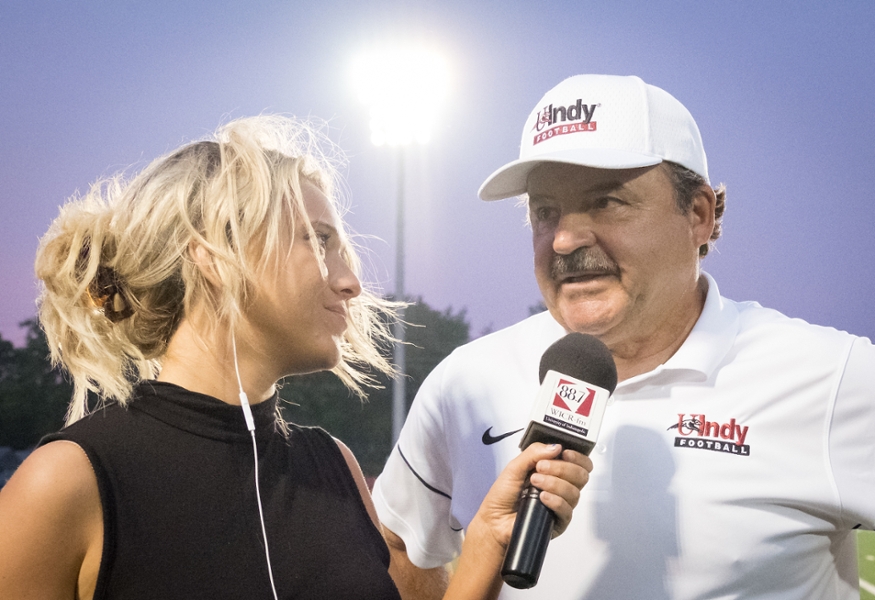 student interviewing a football coach