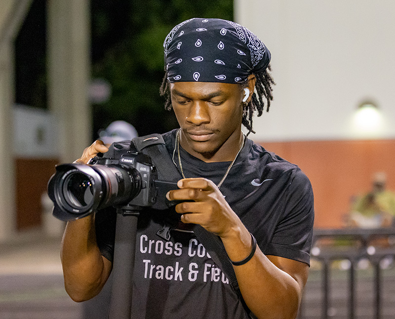 student holding a professional camera