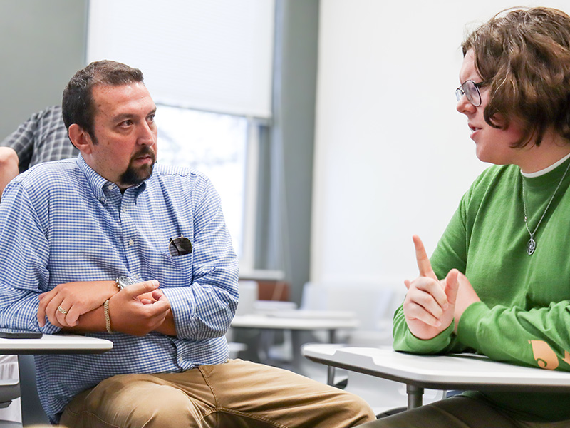 student talking one-on-one with a professor