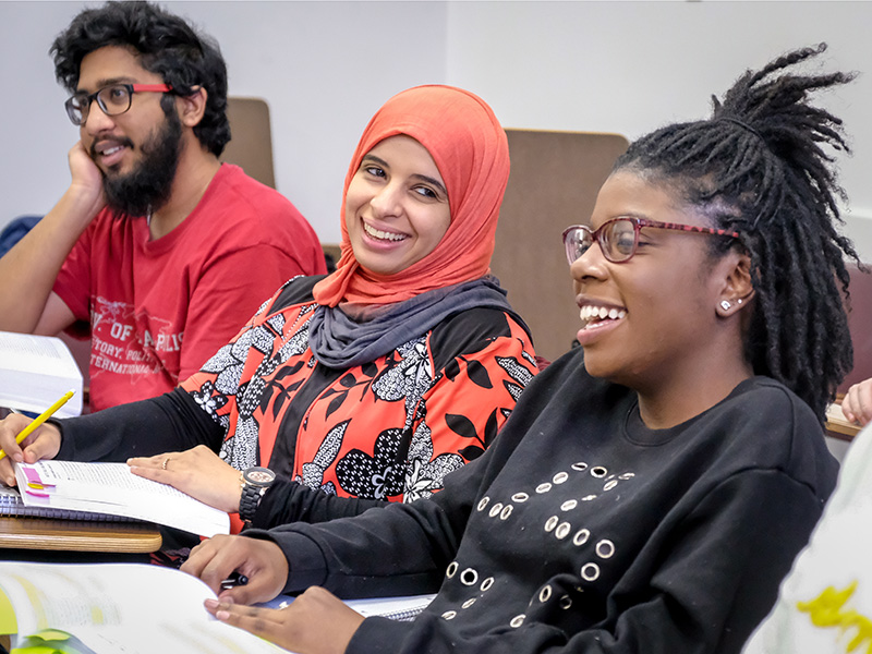 students from diverse backgrounds laughing in class