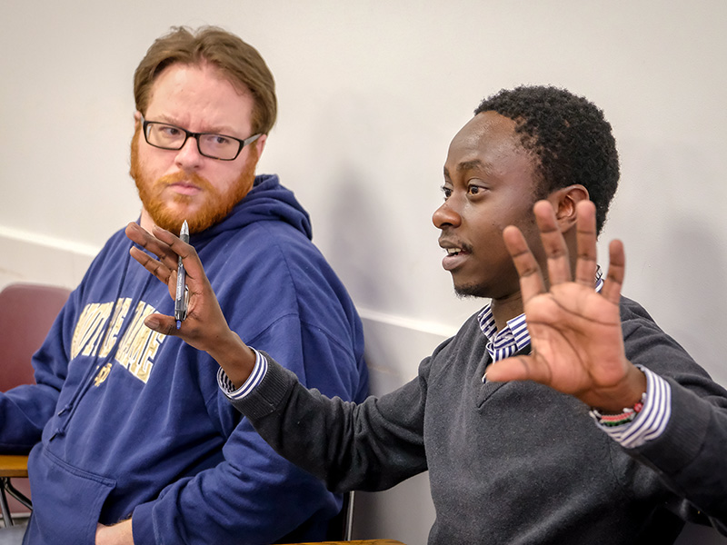 male student is speaking while another is listening to him