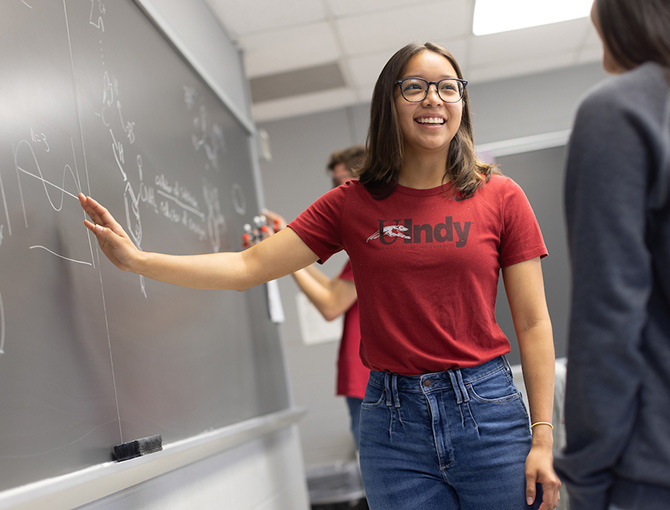 students showing a math equation to another student