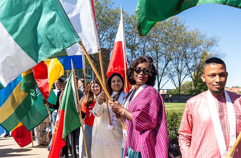 student holding different national flags