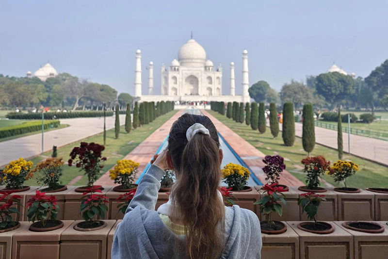tourist taking a photo of a large building (Taj Mahal)
