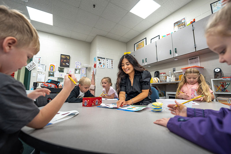 female student engaging with children in class