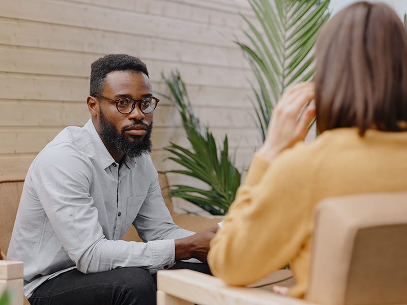 Two people converse in a therapy setting