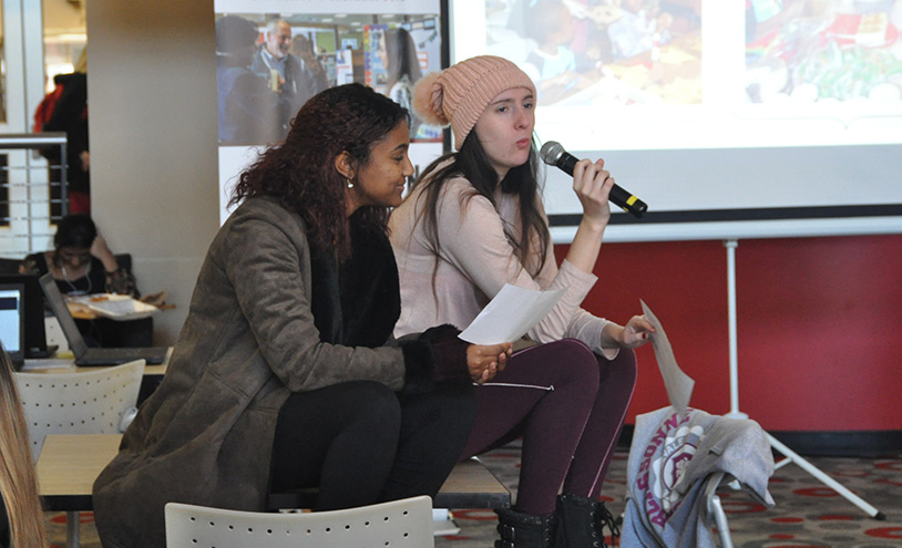 student holding a microphone during a discussion