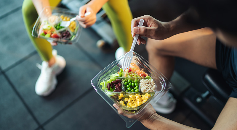 cose up of two active individuals' healthy meals
