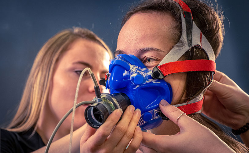 Student being fitted for face mask for metabolic testing in the human performance lab.